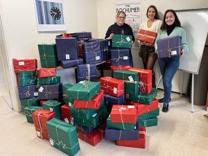 Dinara Quarz-Pleuger, Tiffany Wiener (beide ATAMYA) & Christine Diem (Caritas Bochum) bei der Geschenkübergabe für die Aktion "Weihnachten im Schuhkarton".